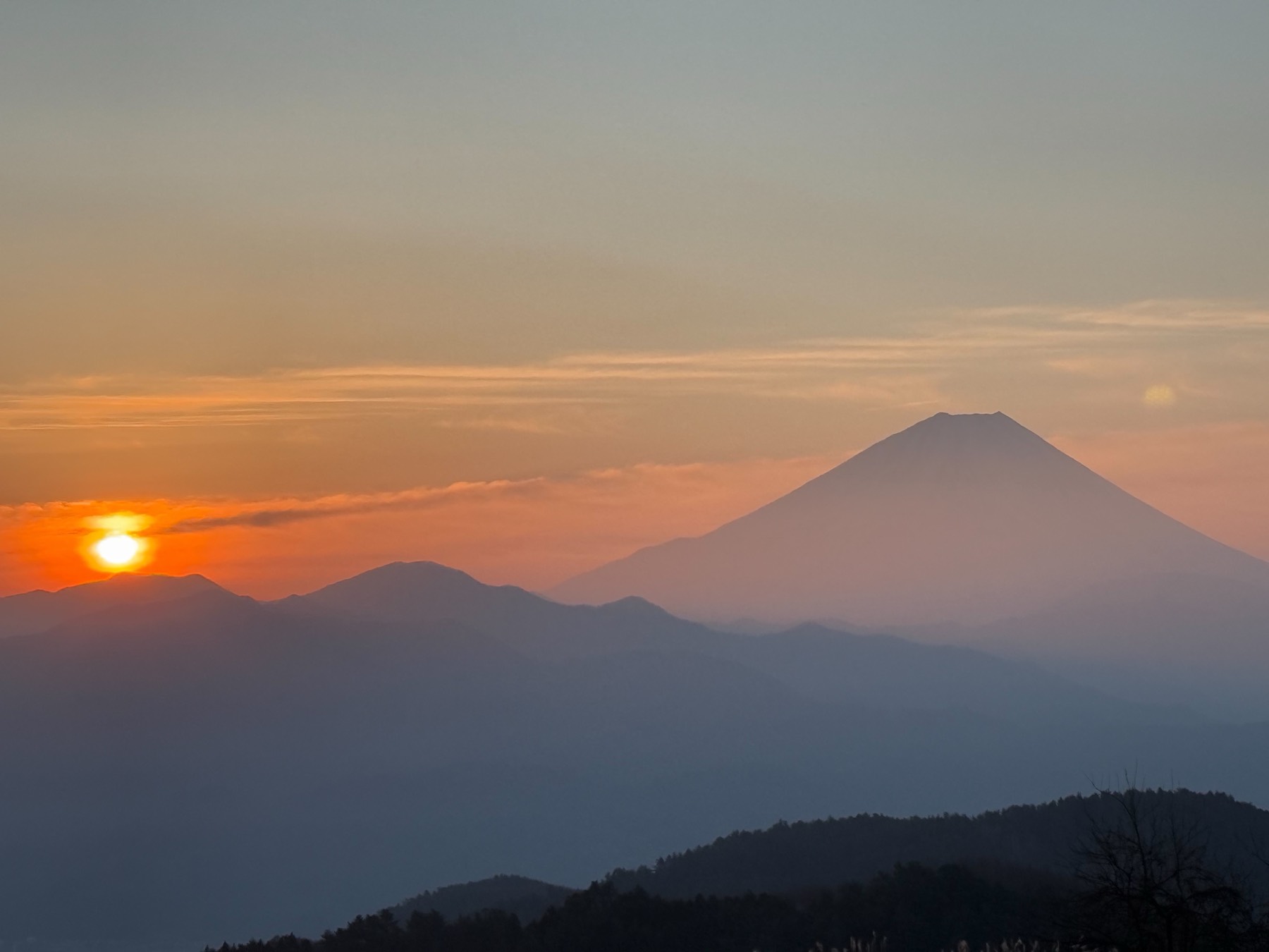 夕暮れの里山と、遠くに望む富士山